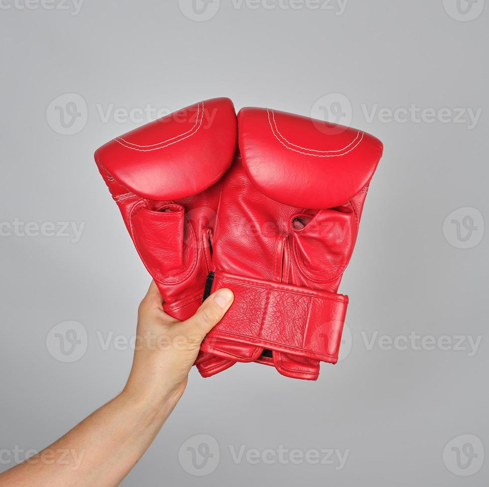 pair of red leather boxing gloves in female hand photo