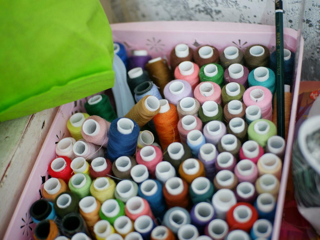 Multicolor sewing threads on wooden background.Color sewing threads on white background, top view photo