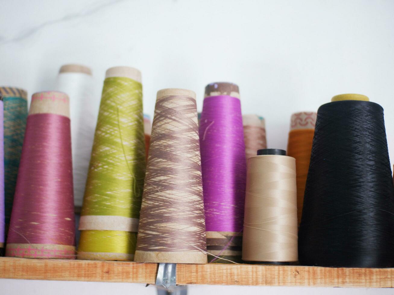 Multicolor sewing threads on wooden background.Color sewing threads on white background, top view photo