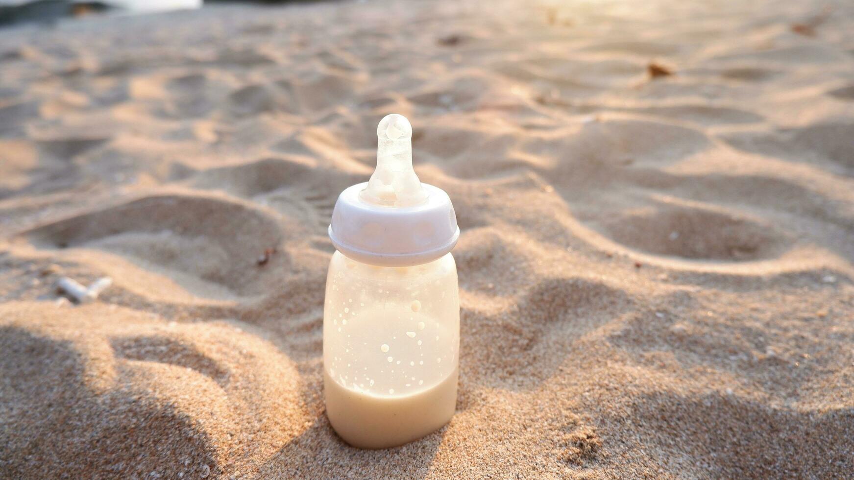 Milk bottle on the beach sand at sunset photo