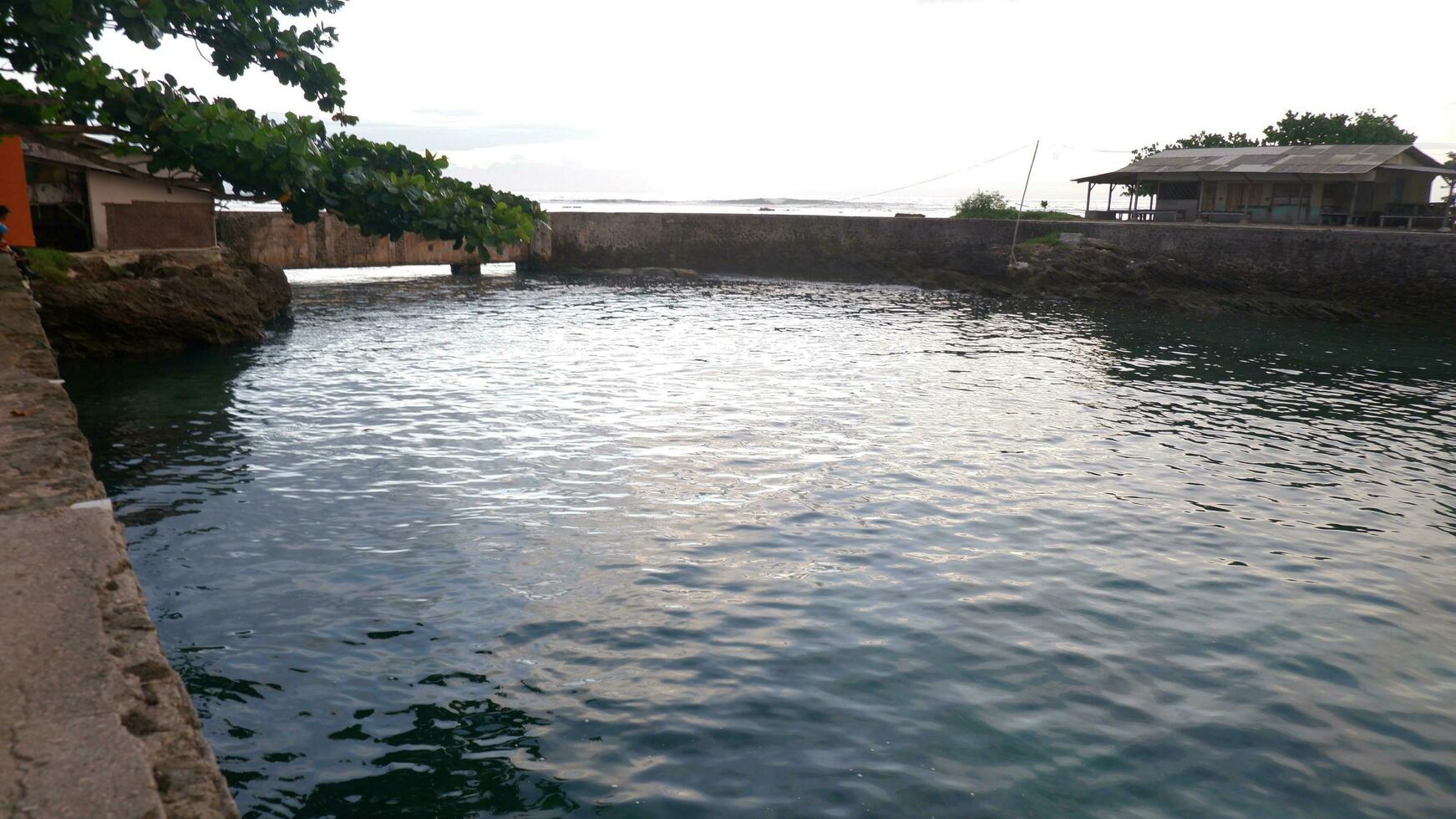 Afternoon sea view and sea-wall, beach, and coral, sunset background on Santolo beach Indonesia photo