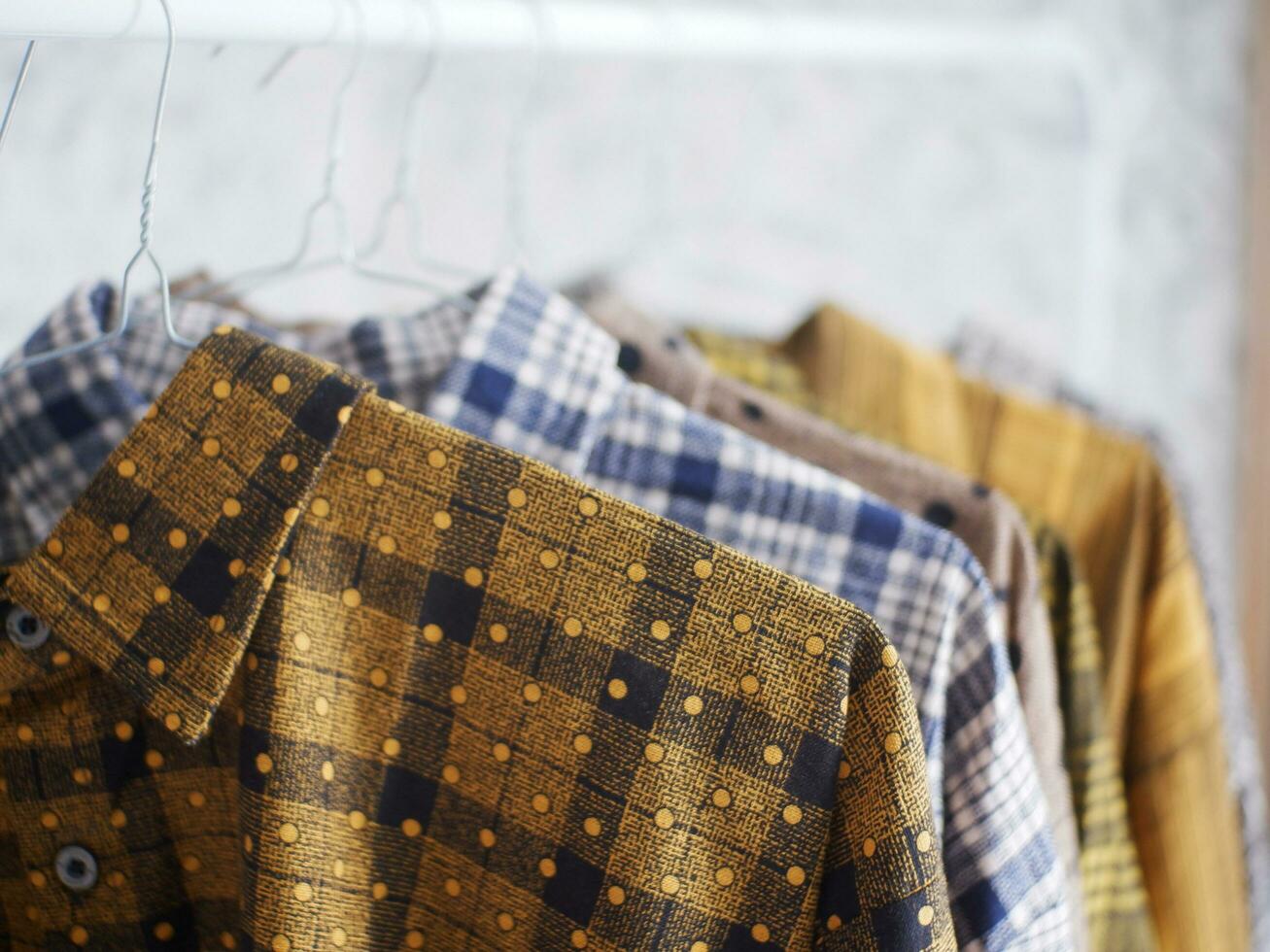 The clothes hanger is Filled with colorful Fabric shirts. shirt shop.Close Up hanging clothes photo