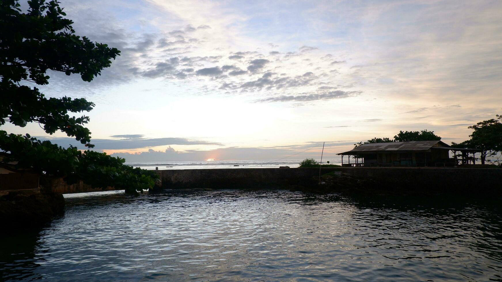 Afternoon sea view and sea-wall, beach, and coral, sunset background on Santolo beach Indonesia photo