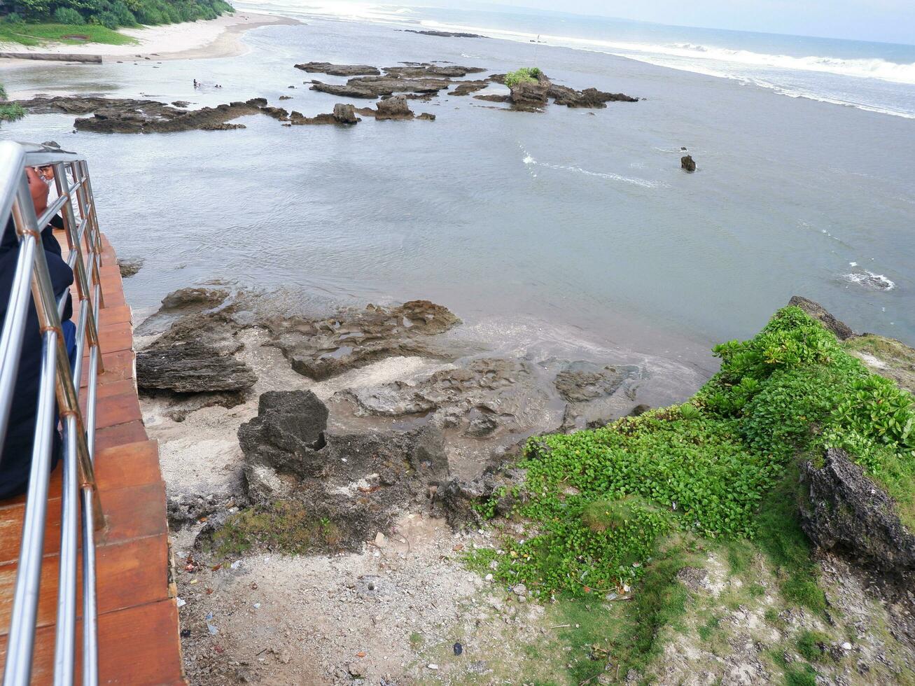 vista de la costa desde arriba, olas blancas, arena de playa, agua clara y rocas. vista panorámica. hermosas playas foto