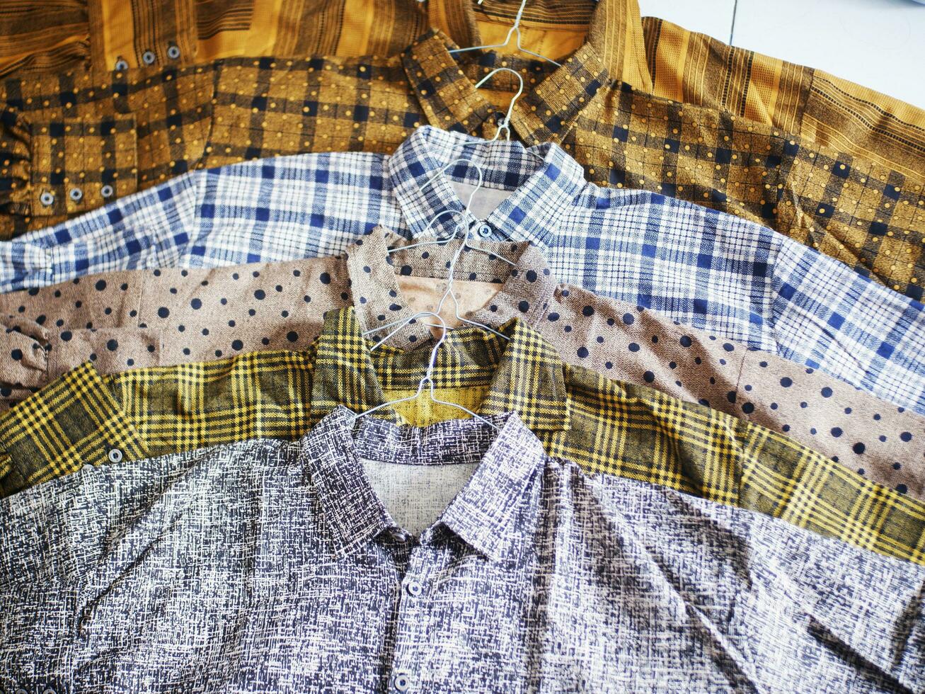 camisas coloridas alineadas ordenadamente. tienda de camisas, camisa abstrac, camisa de lunares foto