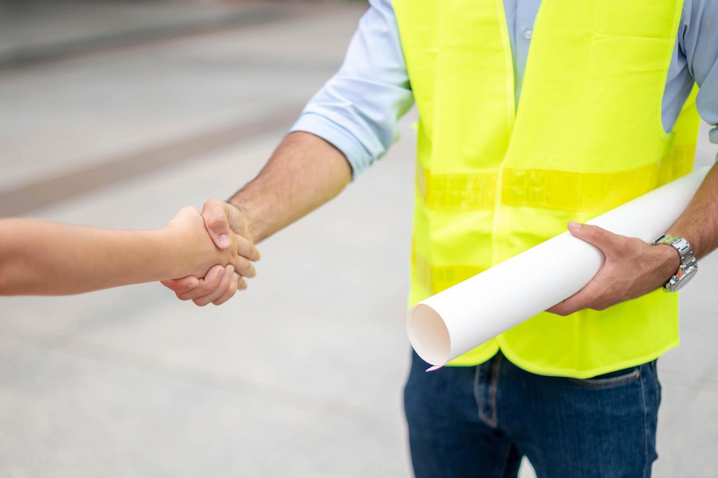 Two engineer shaking hands with deals and success agreement at construction site. Architect and worker handshaking on construction site. photo