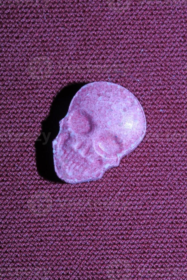 Pink skull ecstasy pill close up background high quality print purple army dope narcotics substance high dose psychedelic way of life photo
