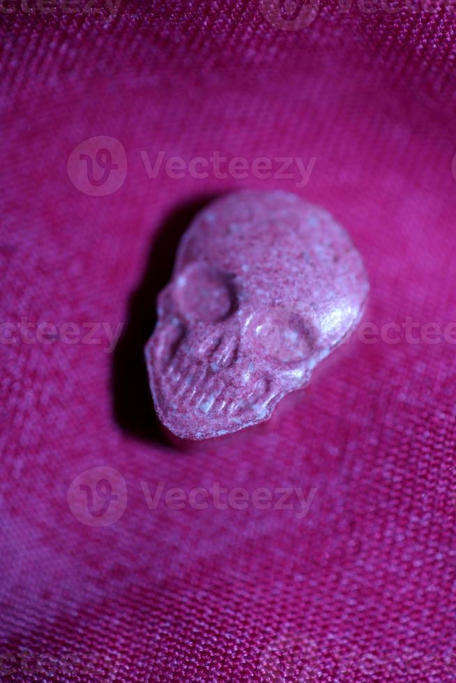 Pink skull ecstasy pill close up background high quality print purple army dope narcotics substance high dose psychedelic way of life photo