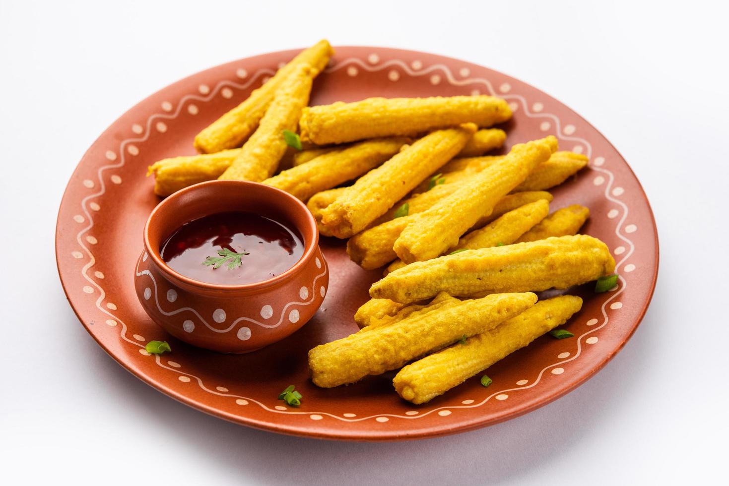 Pakoda de maíz frito crujiente, pakora o buñuelos de maíz para bebés servidos con ketchup, comida india foto