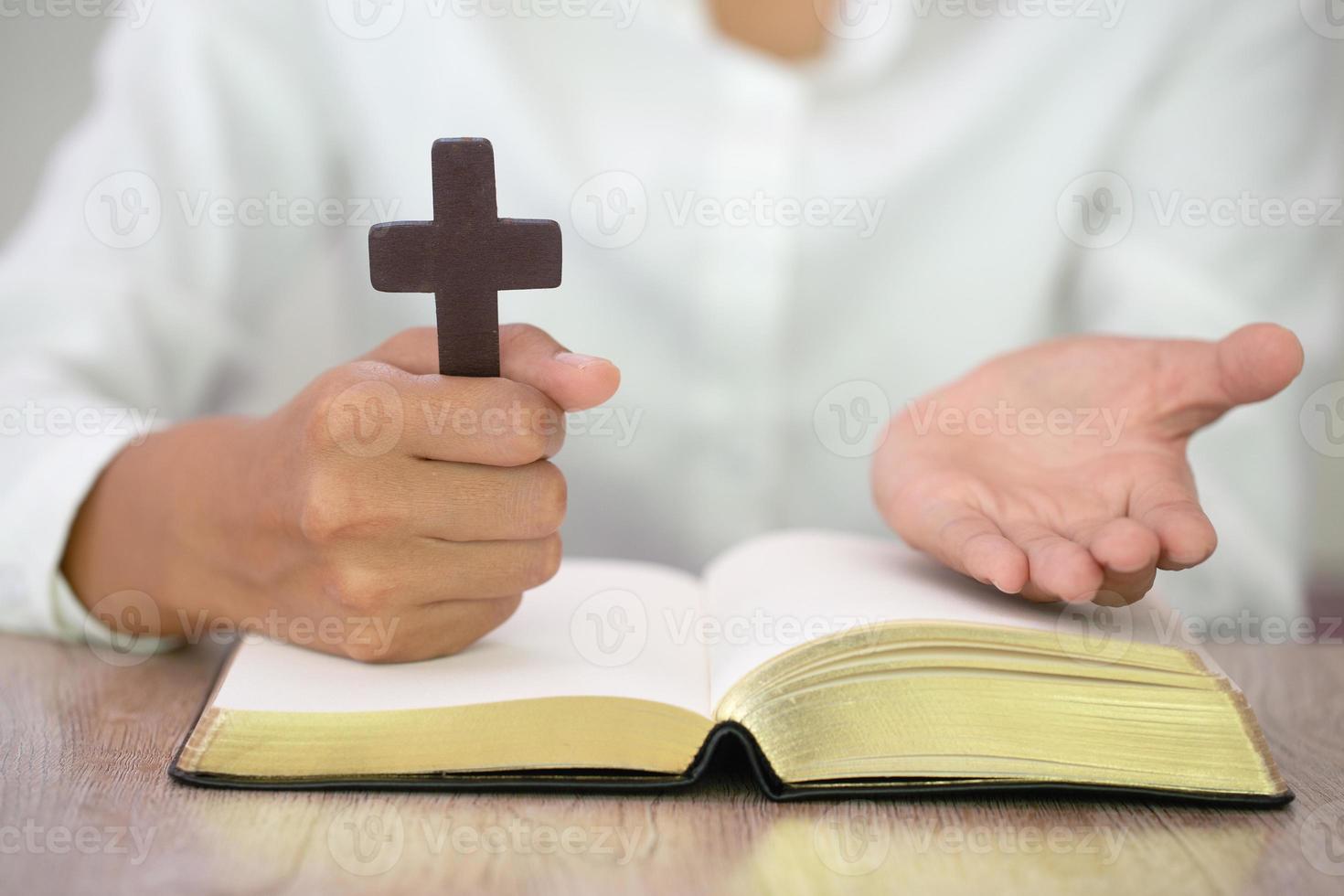 Woman with  cross  in hands praying for blessing from god  in the morning, spirituality and religion photo
