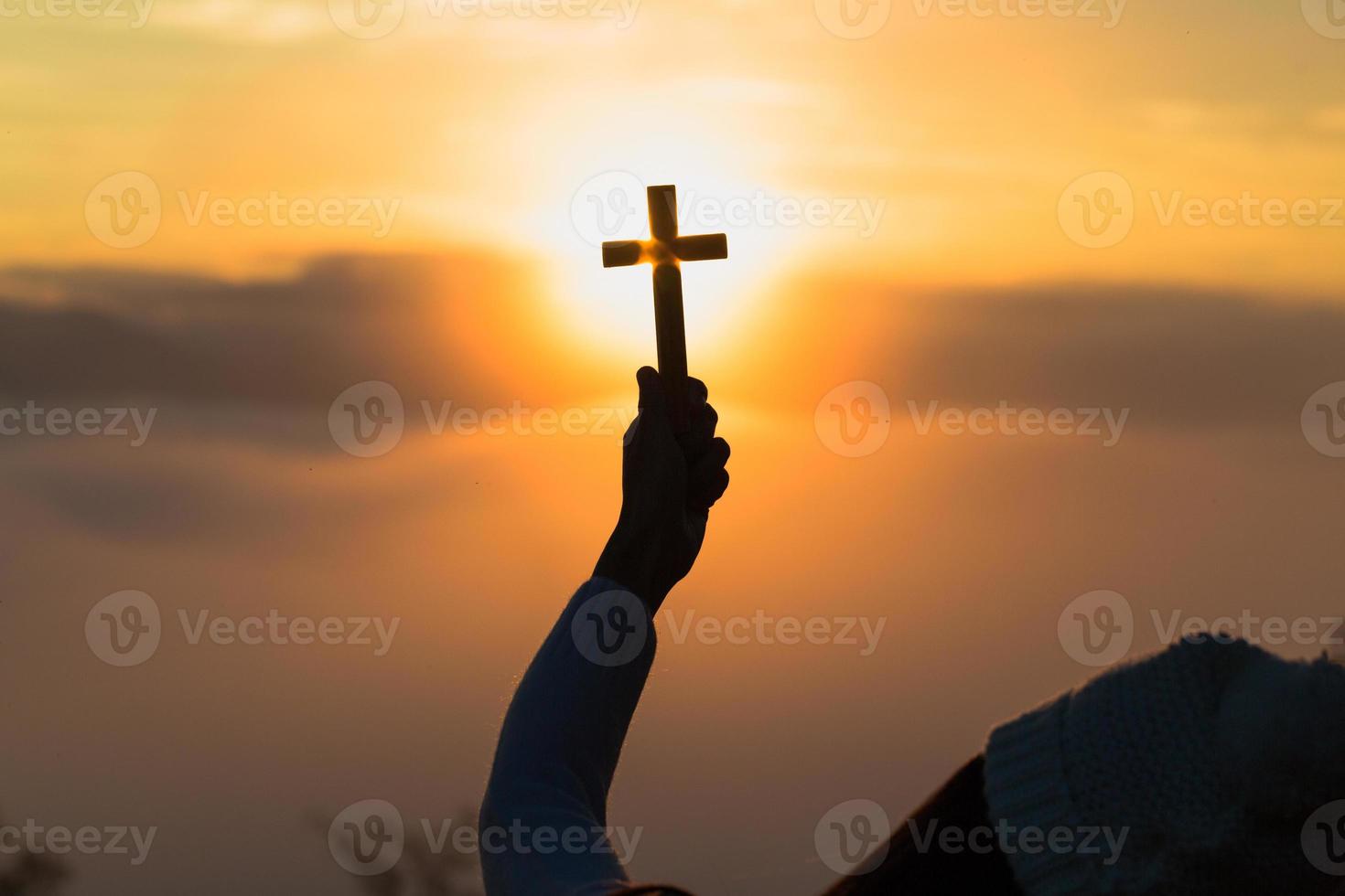 Silhouette of woman  praying with cross  in nature sunrise background,  Crucifix, Symbol of Faith. Christian life crisis prayer to god. photo