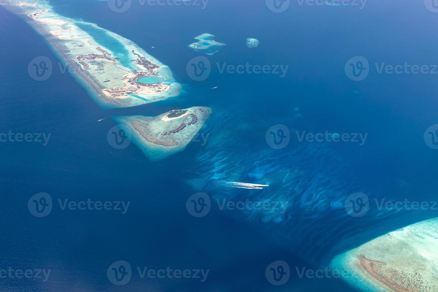 Aerial view of Maldives islands and atolls. Maldives tourism and travel background. Amazing blue sea, coral reef and atoll drone view. Beautiful nature landscape, seascape, exotic destination photo