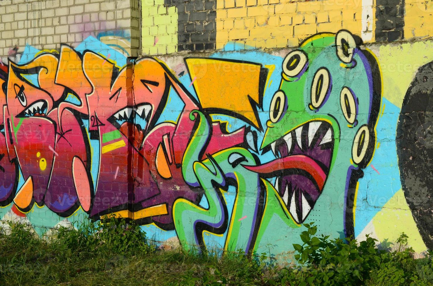 Fragmento colorido abstracto de pinturas de graffiti en la pared de ladrillo antiguo con cara de pulpo aterrador. composición de arte callejero con partes de letras no escritas y personajes de dibujos animados foto