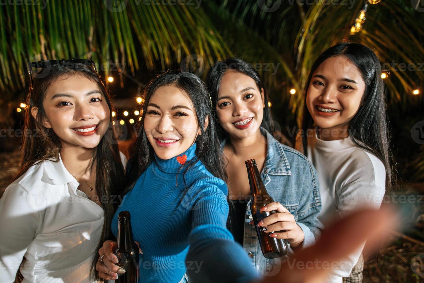 Portrait of Happy Asian friends having dinner party together - Young people toasting beer glasses dinner outdoor  - People, food, drink lifestyle, new year celebration concept. photo