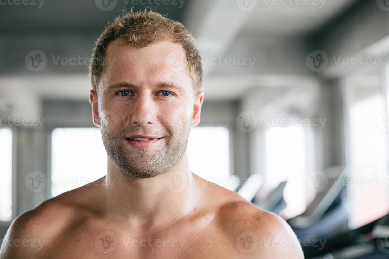 Portrait of topless Caucasian man smiling to camera standing in the fitness photo