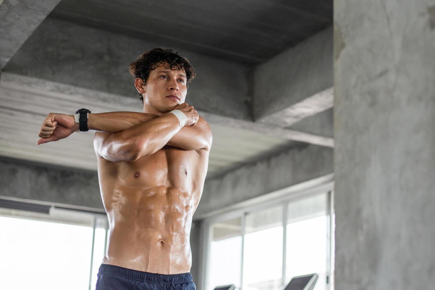 Topless athlete man warm up exercise before workout at the fitness photo