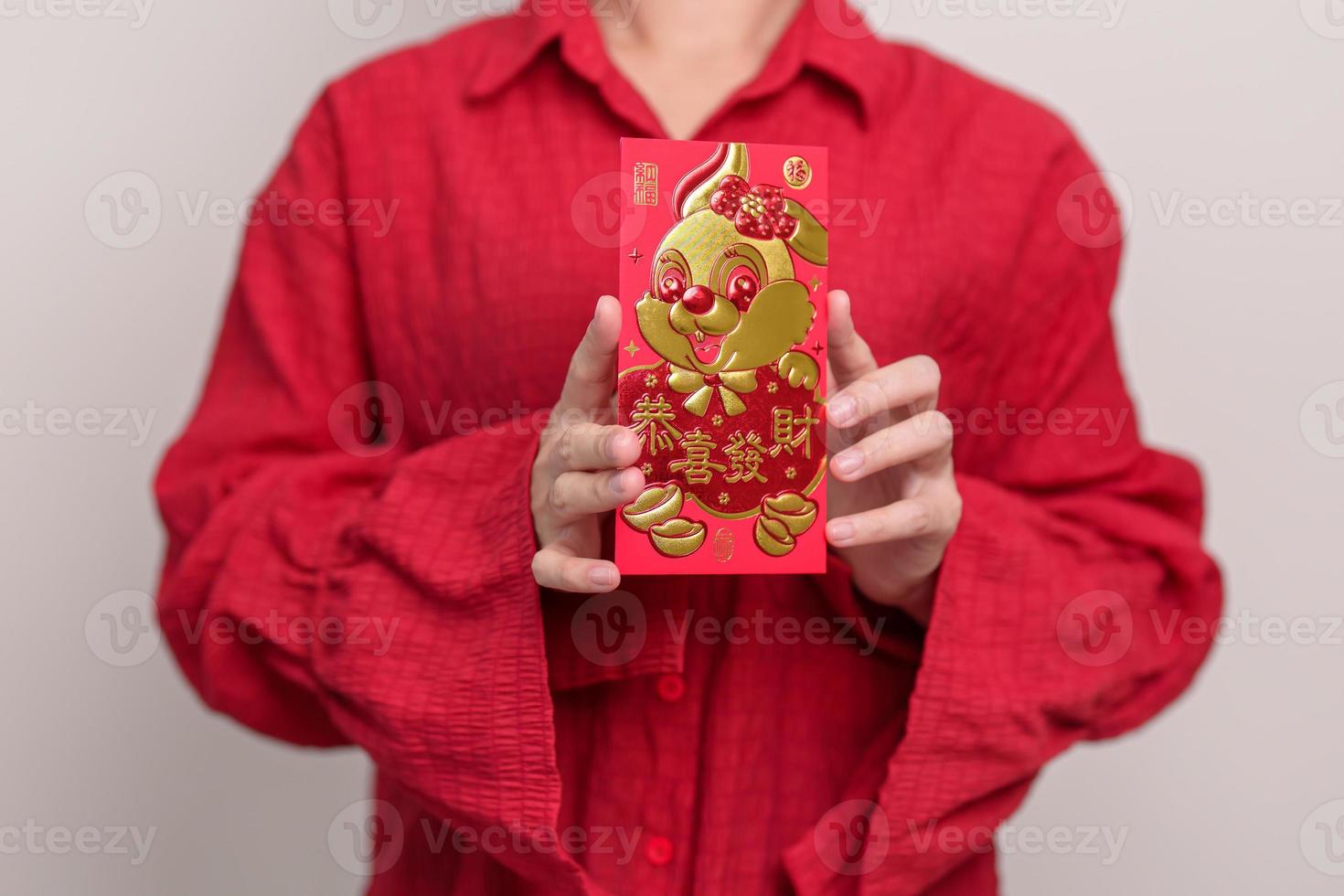 mujer sosteniendo un sobre rojo chino con conejo dorado y palabra de bendición, regalo de dinero para felices vacaciones de año nuevo lunar. frase china significa felicidad, salud, suerte y riqueza foto