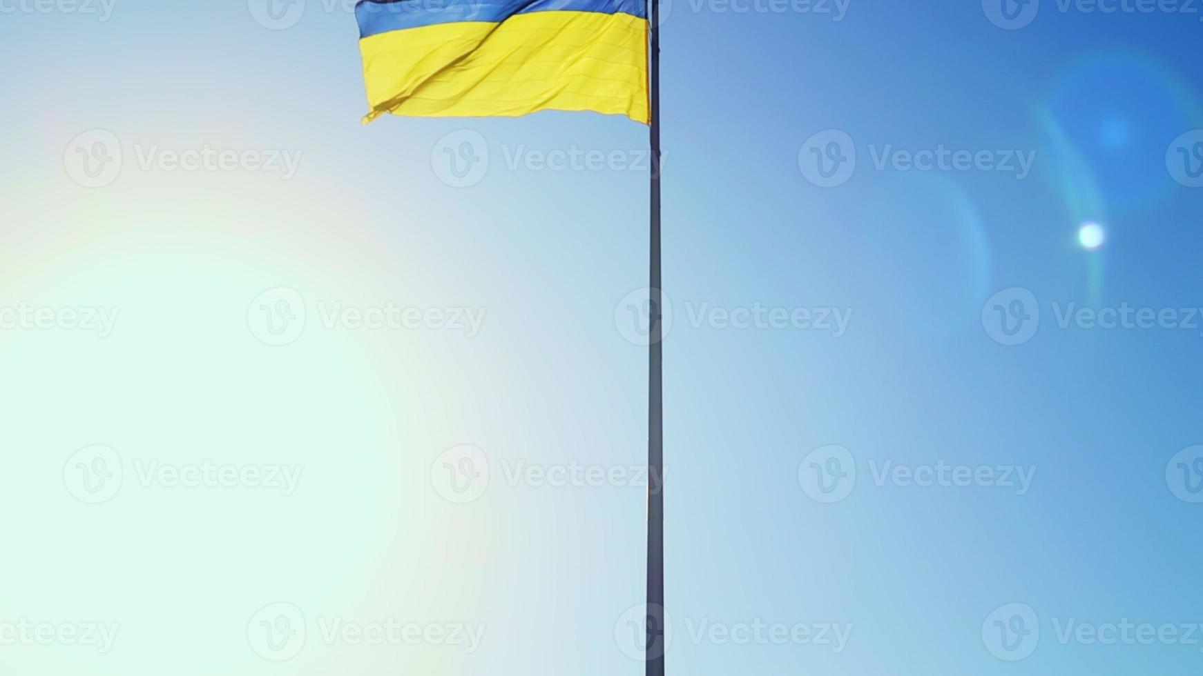 Slow motion flag of Ukraine waving in the wind against a sky without clouds at dawn of the day. Ukrainian national symbol of the country is blue and yellow. Flag loop with detailed fabric texture. photo