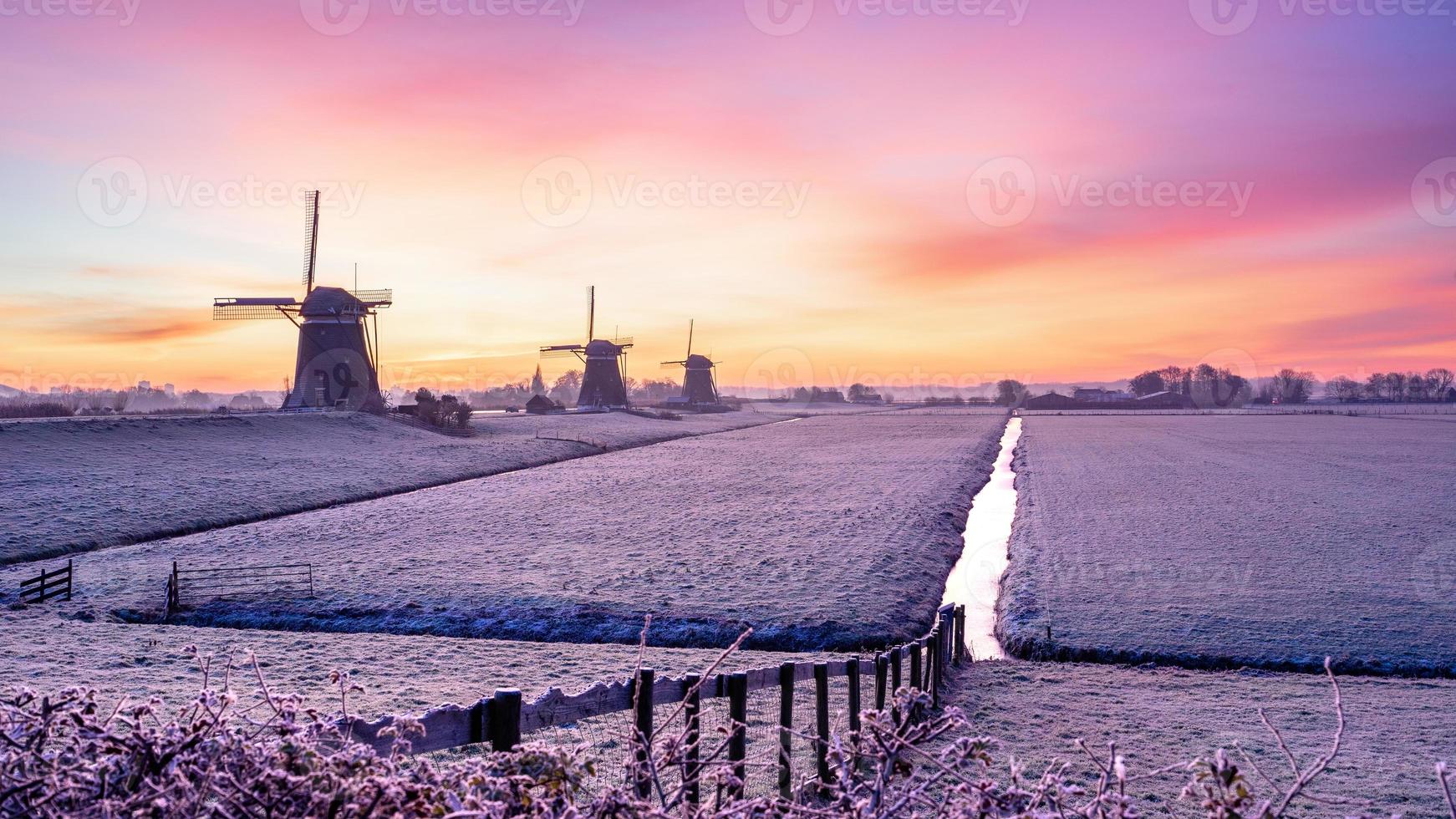 The three windmills at Stompwijk in The Netherlands. Duringu a verg cold morning, but with a beautiful sunrise. photo