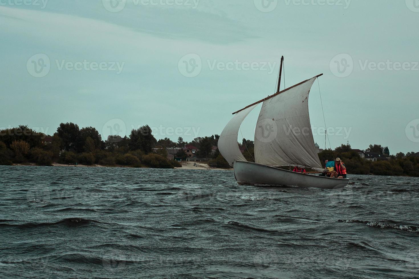 velero flotando en el agua sombrío paisaje foto