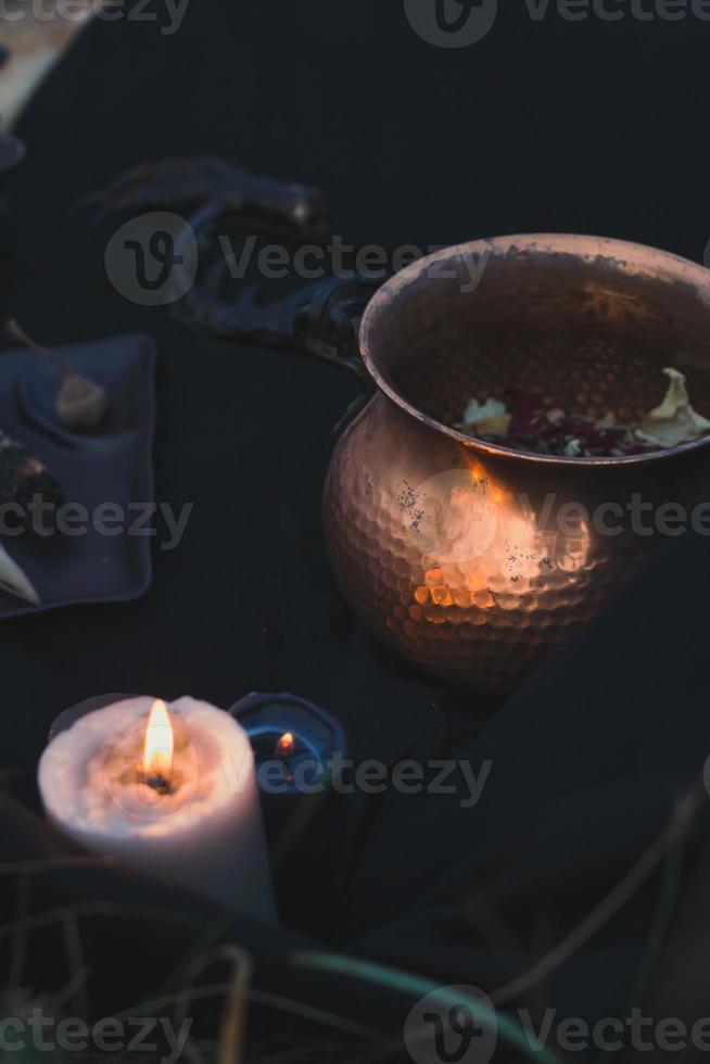 Close up witch cauldron and burning candle concept photo