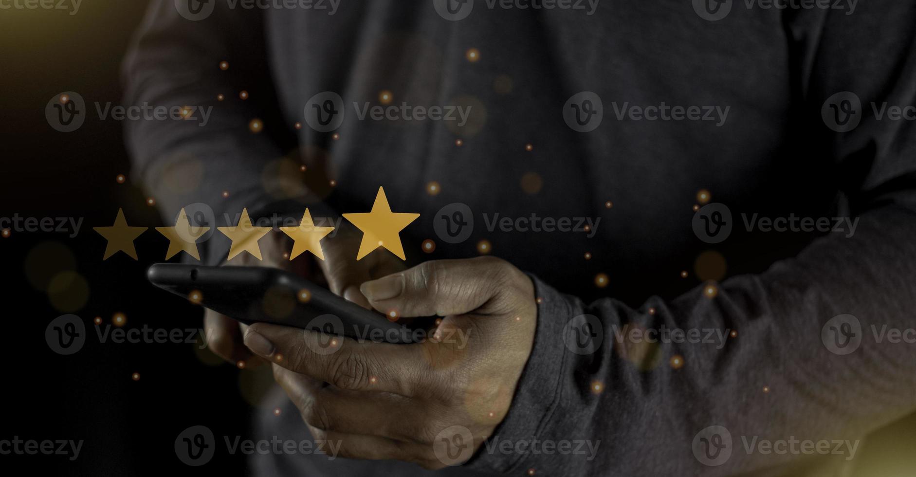 Satisfaction close up on customer man hand pressing on screen with five star rating feedback icon and press level excellent rank for giving best score point to review the service concept photo