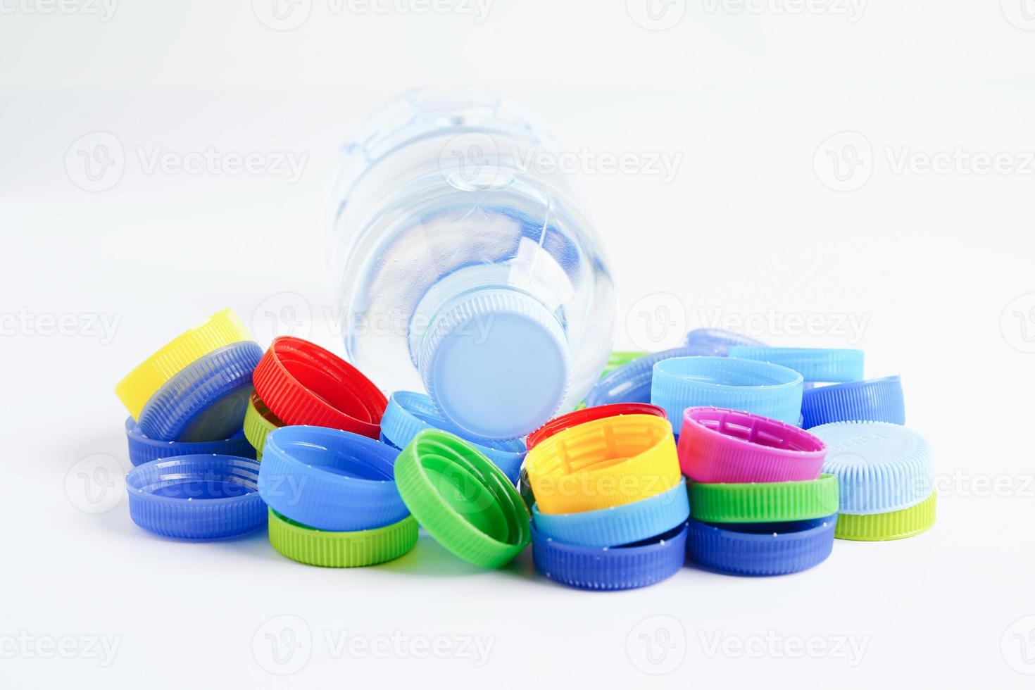 tapas de botellas de plástico de colores para reciclar sobre fondo blanco. foto