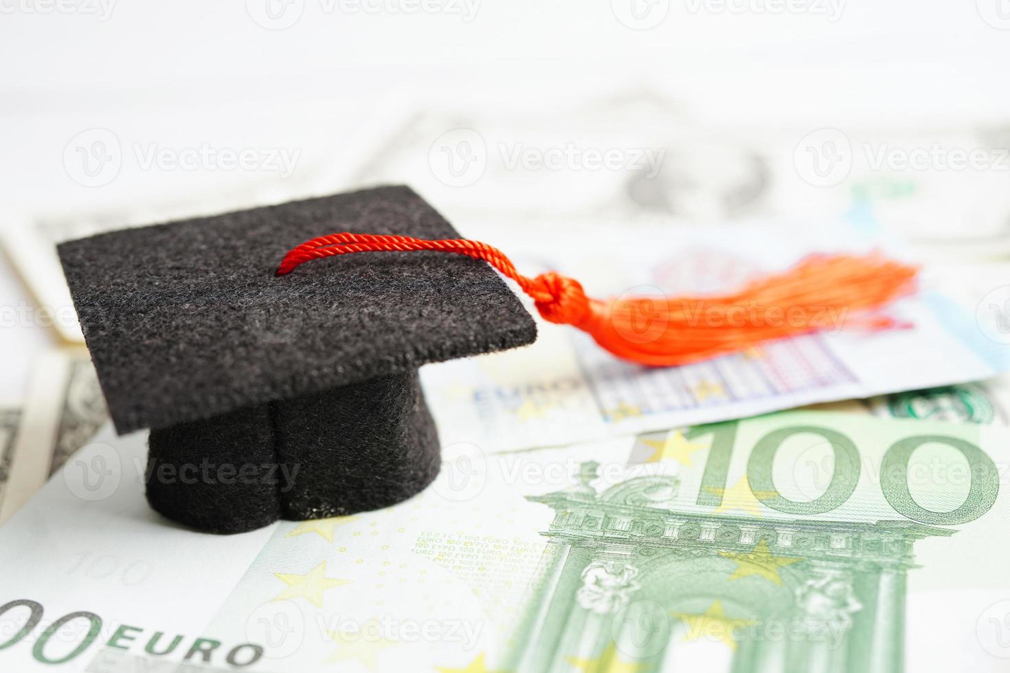 Graduation gap hat on Euro and US dollar banknotes money, Education study fee learning teach concept. photo