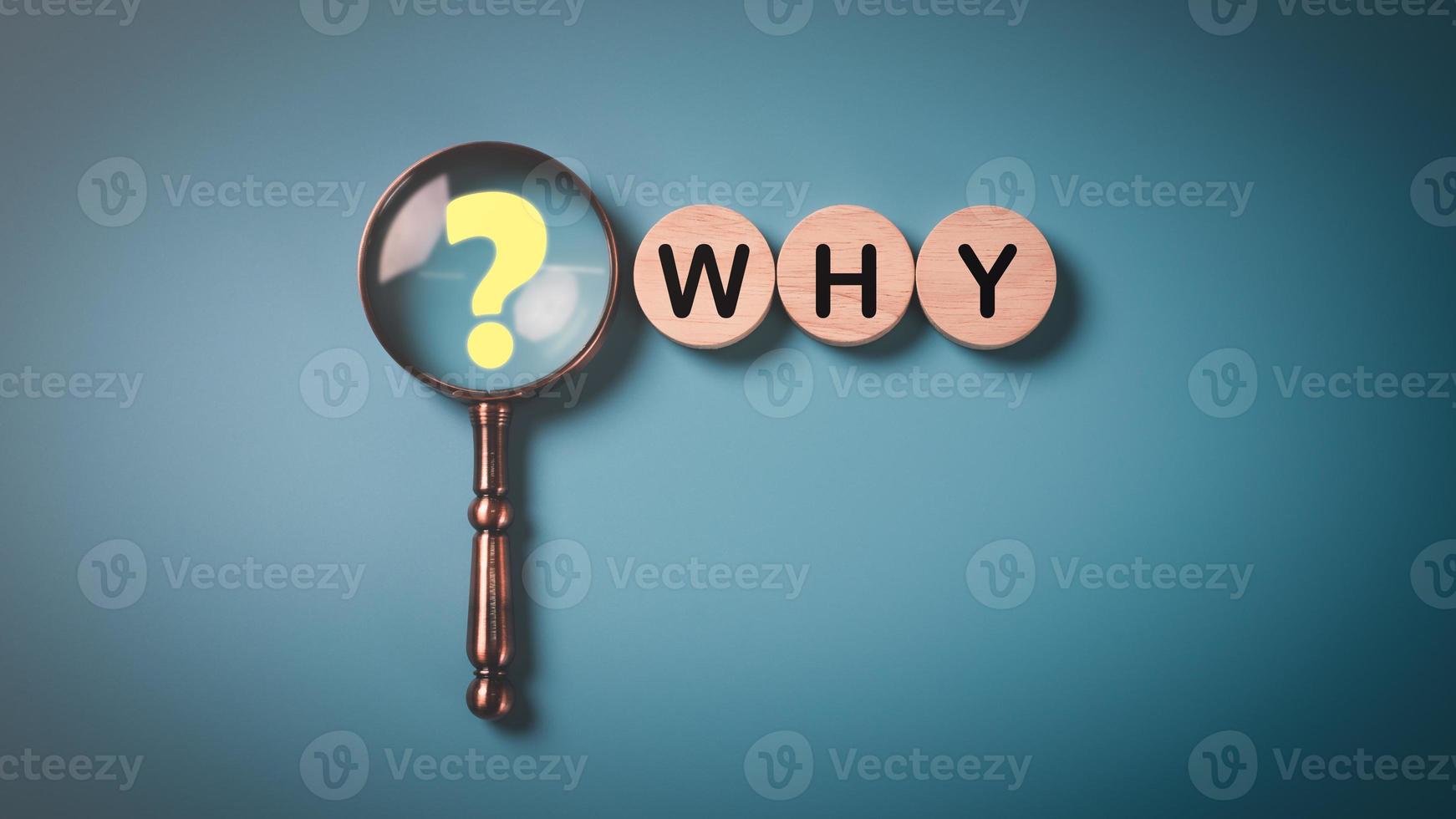 Question mark on magnifying glass and wooden block on a blue background, Questioning concepts, why, where, when, how, who ,to find the answer , and ask for help to solve the problem. photo