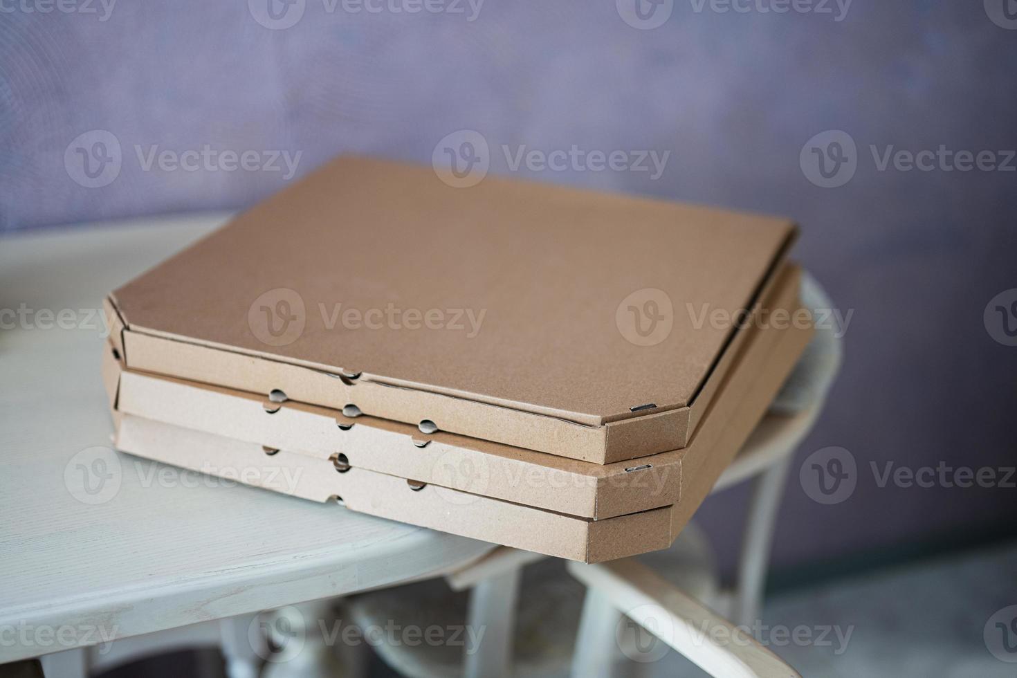 Cardboard pizza boxes on kitchen in table. photo