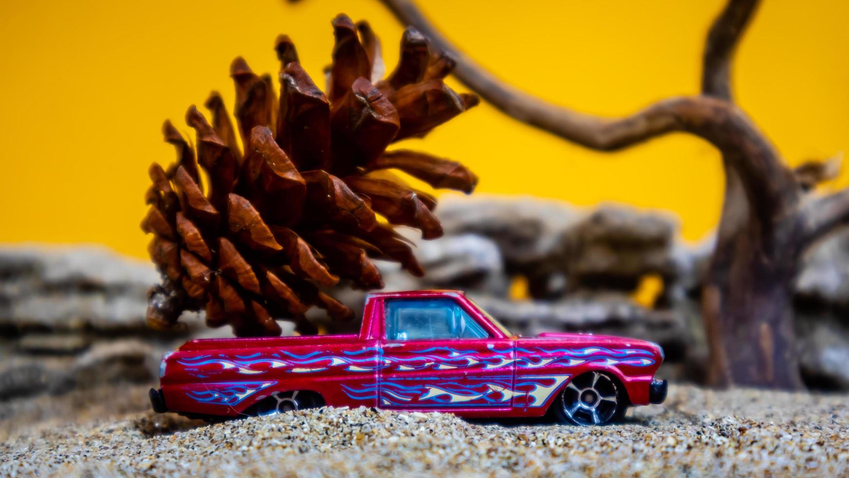 toy car hauling pinecones on an orange background photo