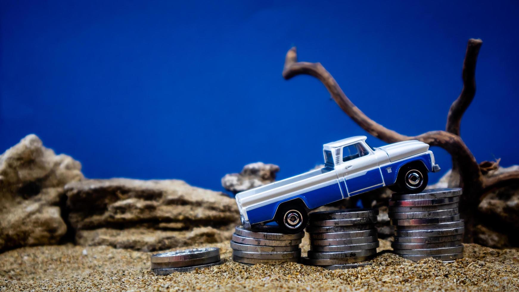 minahasa, Indonesia  January 2023, toy car on a pile of coins, saving for the future, managing successful transportation business technology concept photo