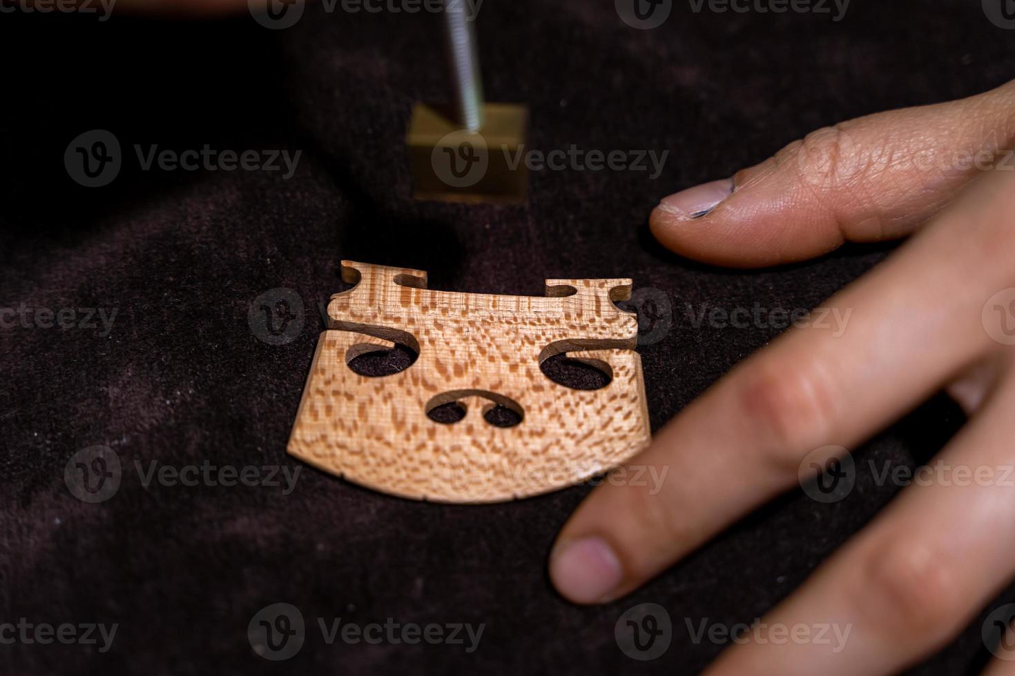 young Chinese woman violin maker signs the jumper of her violin with fire with her name photo