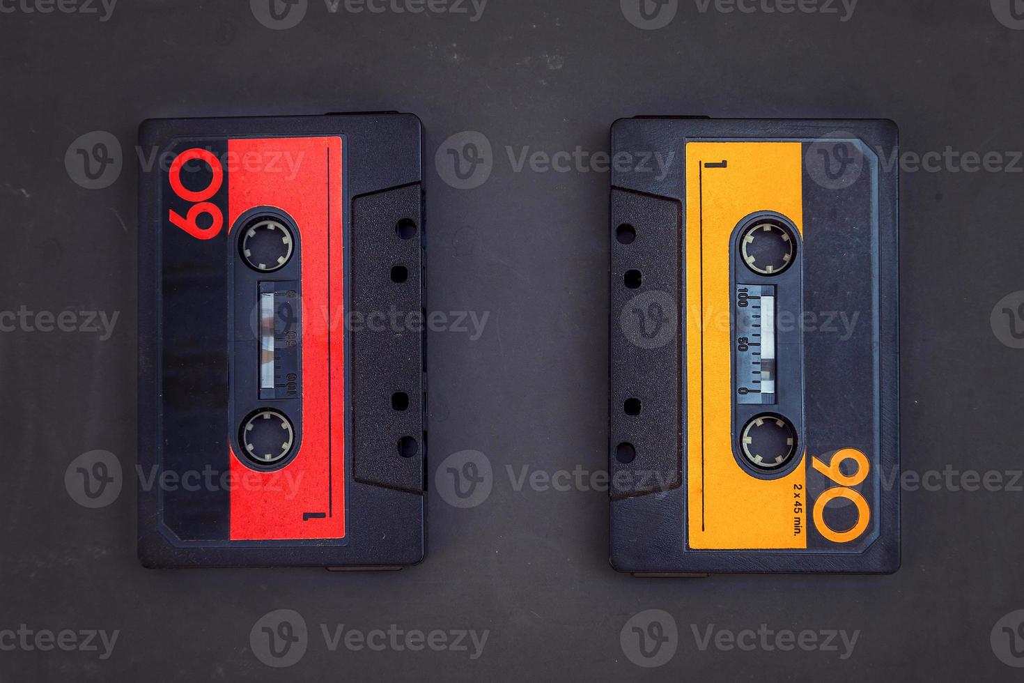 pair of vintage audio cassettes over a black chalkboard photo