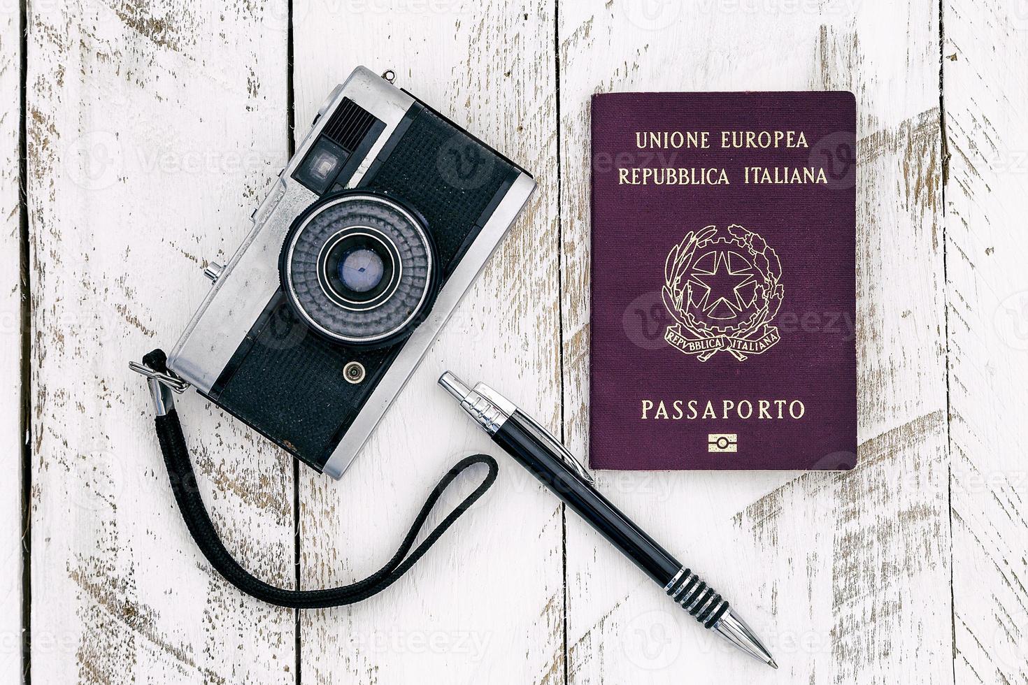 pasaporte cámara vintage y lápiz sobre madera foto