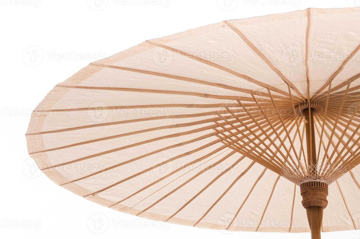 Traditional Asian paper and bamoo umbrella with a rounded handle on white background photo