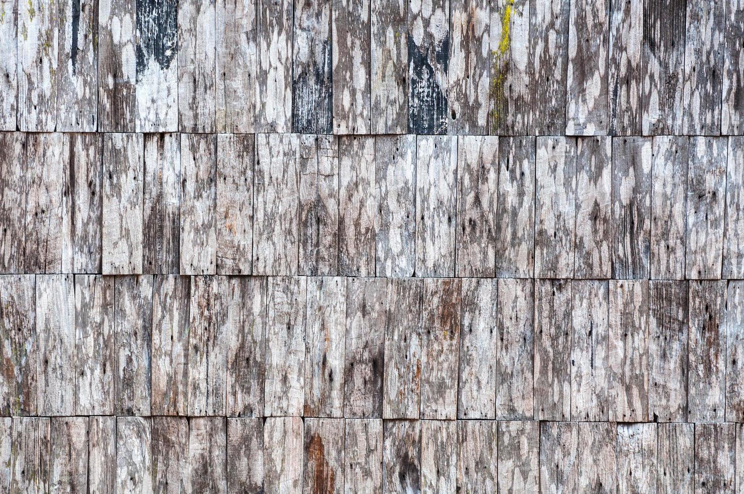 exterior de pared de madera antigua expuesta, mosaico de madera cruda formando un hermoso patrón de madera de parquet foto