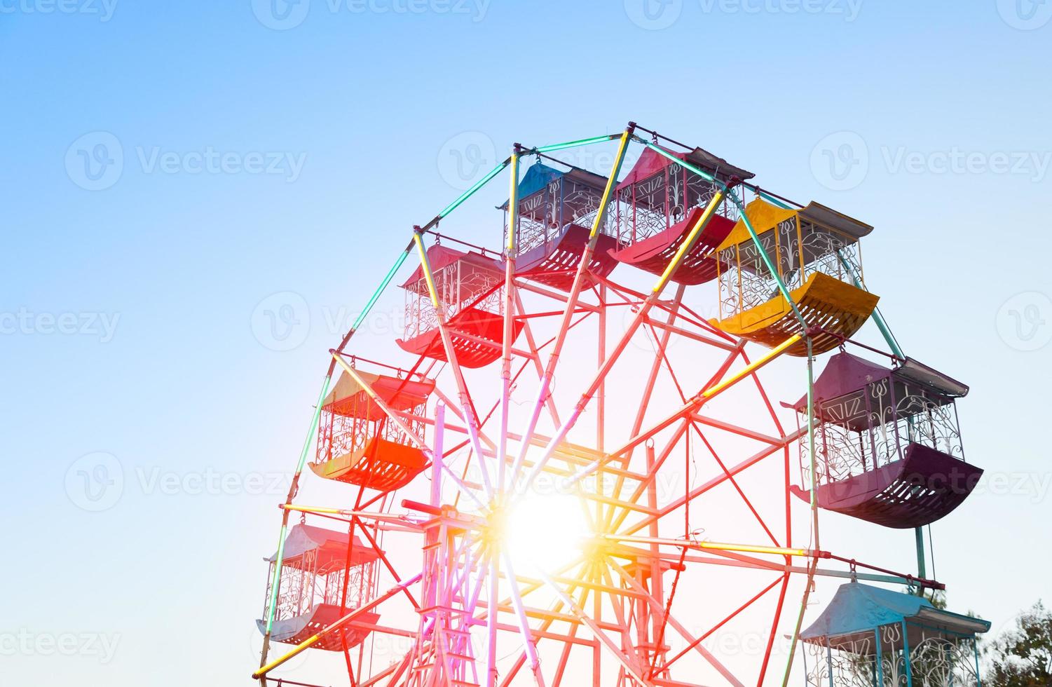 jugador de rueda de ferris de los niños divertidos con cielo azul, rueda de ferris antigua y vintage foto