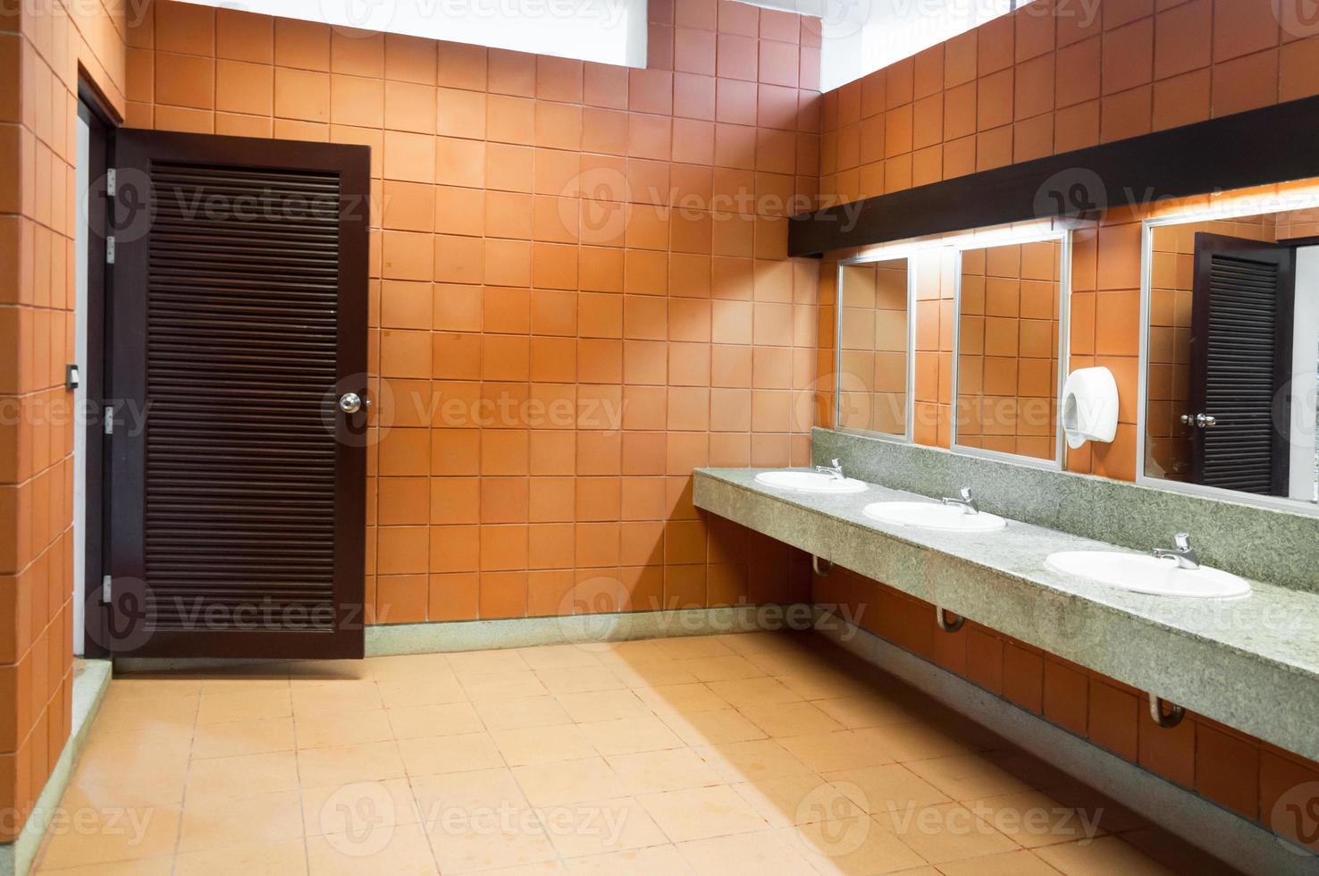 Interior of public clean toilet in a shared toilet there is a wide selection of sinks with mirrors photo