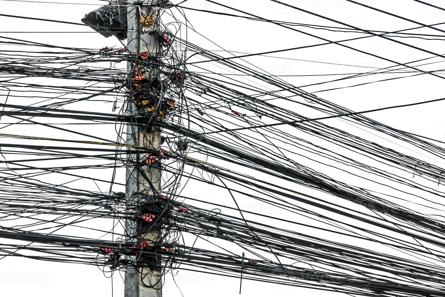 caos desordenado de cables con cables en poste eléctrico sobre fondo blanco, los muchos cables eléctricos en los postes de energía foto
