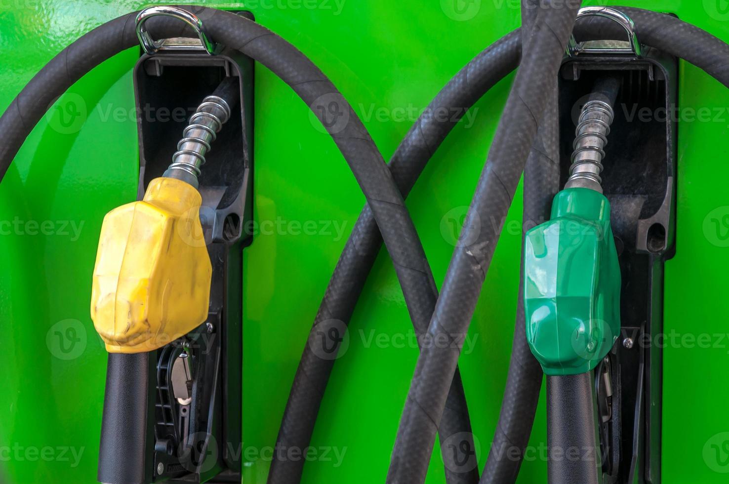 yellow and green petrol gas pump nozzles in a service station,Fuel nozzle in oil station Thailand photo