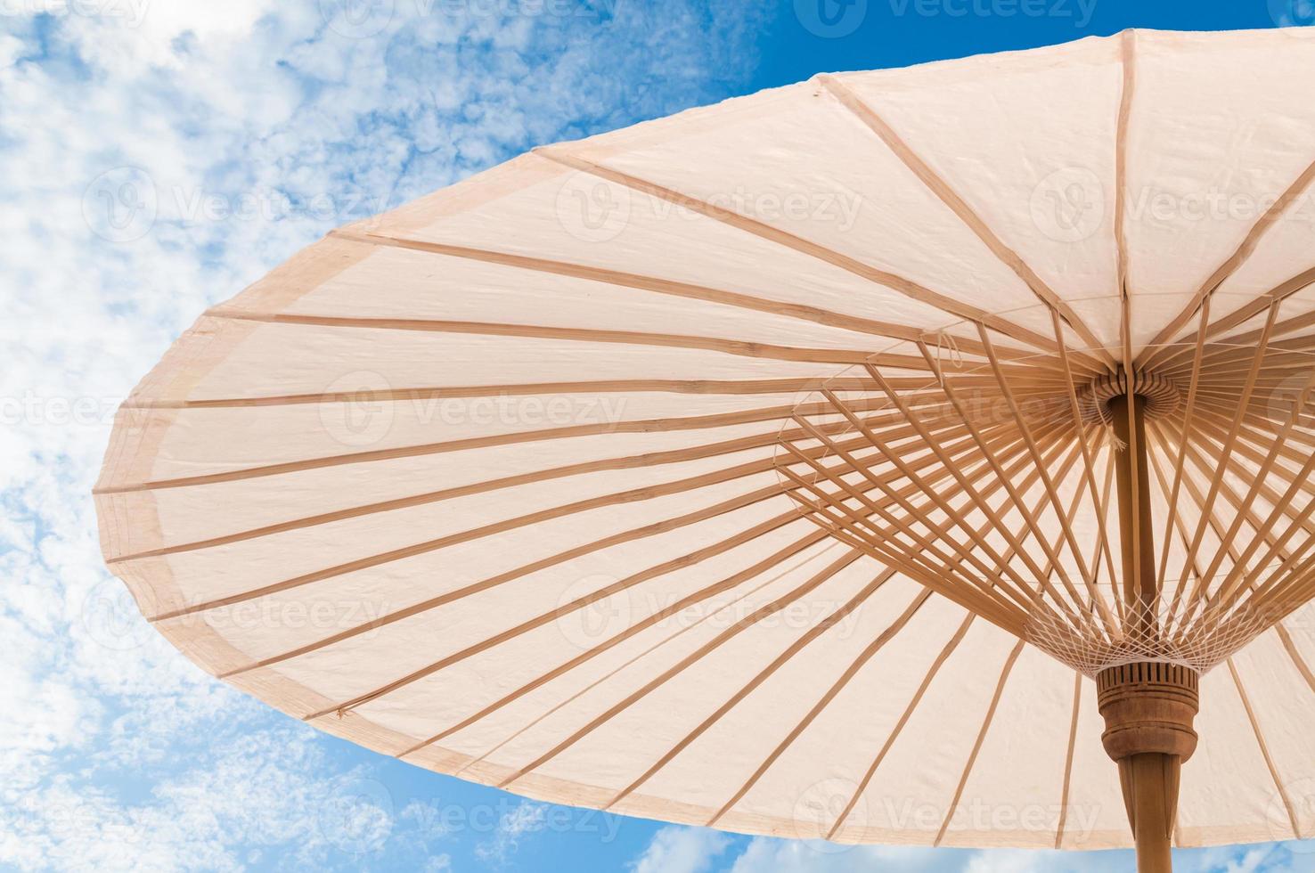 beautiful  Traditional Asian paper and bamoo umbrella with a rounded handle on blue sky photo