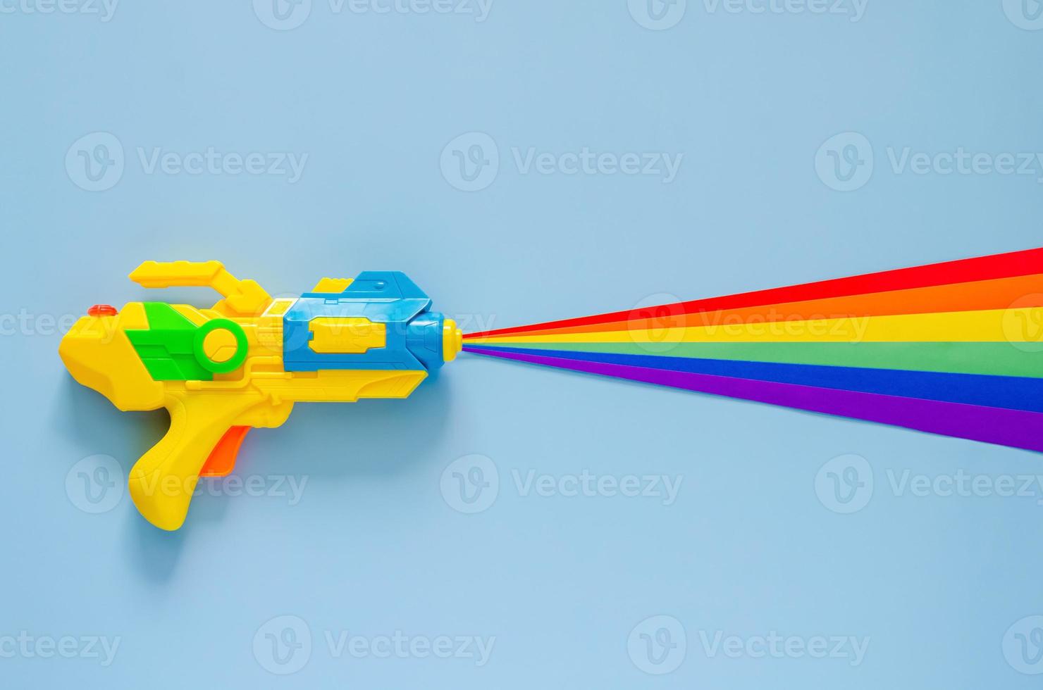 Water gun spray out with colorful cutting paper for Songkran festival celebration on blue color background. Minimal holiday concept. photo