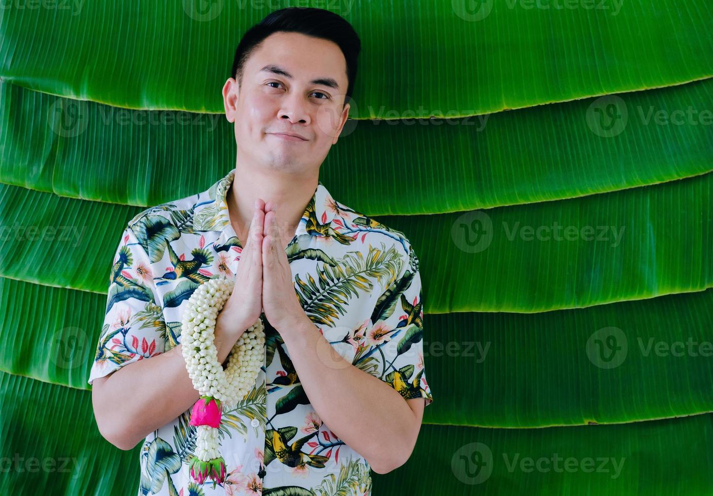 Thai man doing pay respect posture with jasmine garland on his arm to do blessing for Songkran festival concept. photo