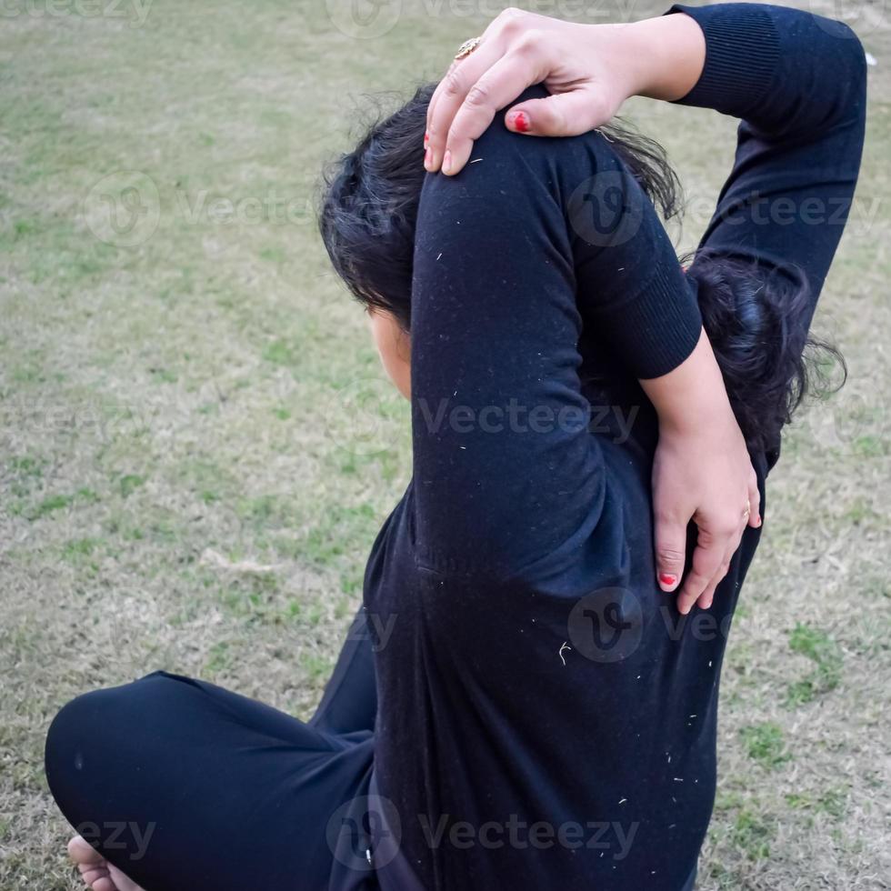 joven india practicando yoga al aire libre en un parque. hermosa chica practica pose básica de yoga. calma y relax, felicidad femenina. posturas básicas de yoga al aire libre foto