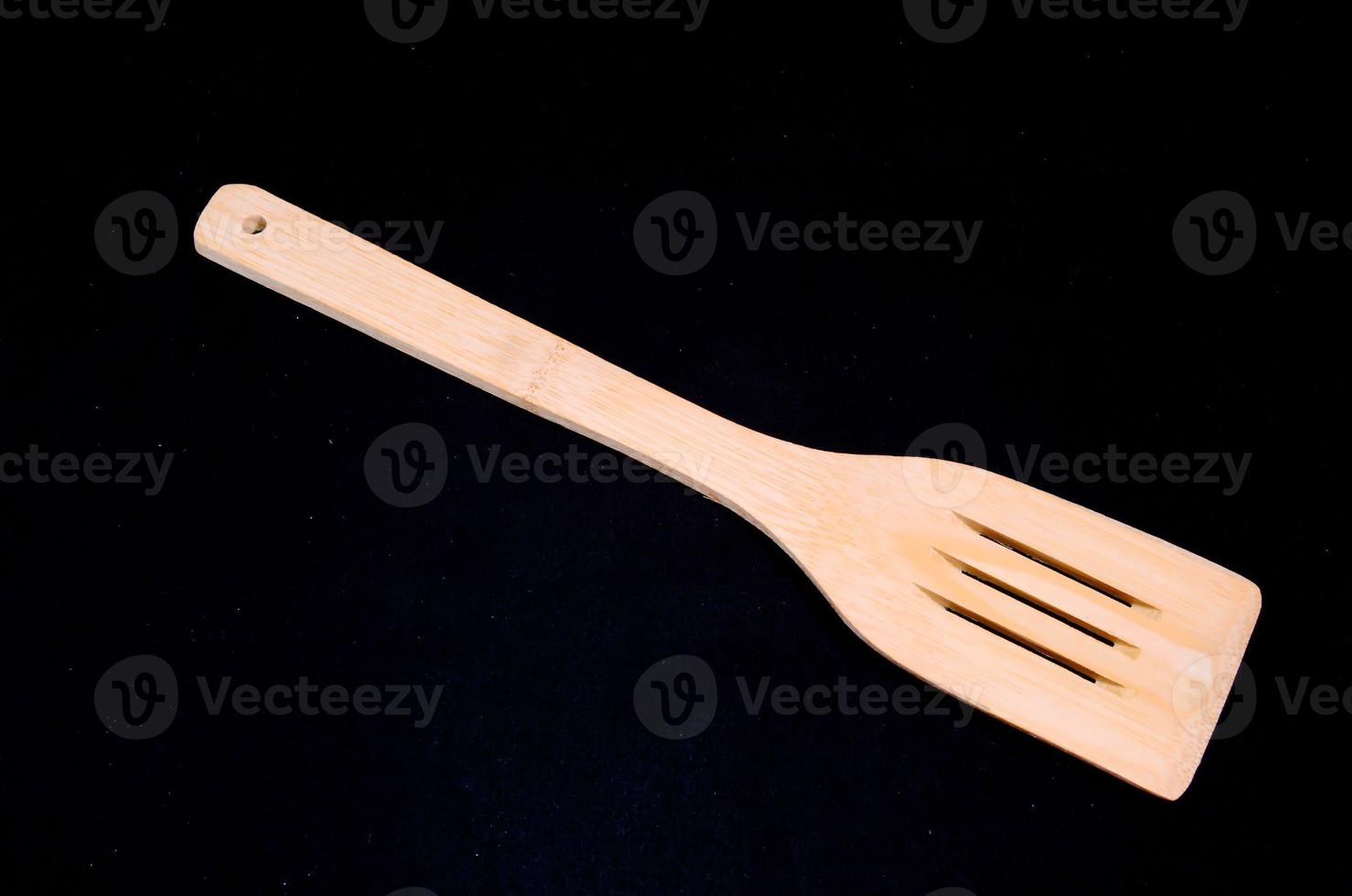Wooden spoon on black background photo