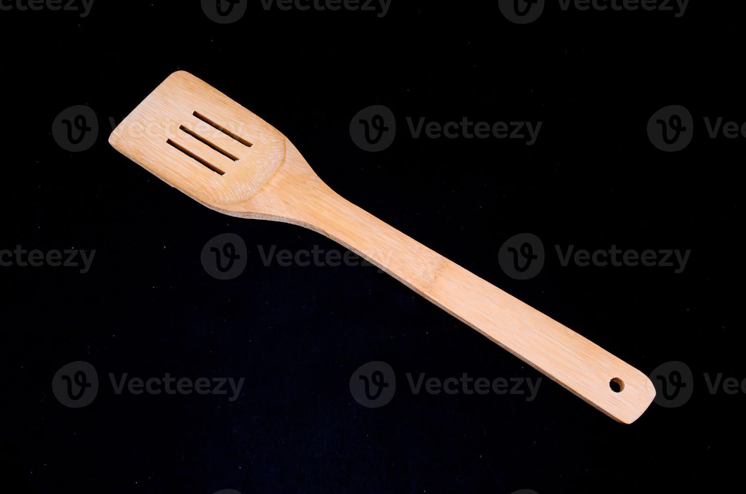 Wooden spoon on black background photo