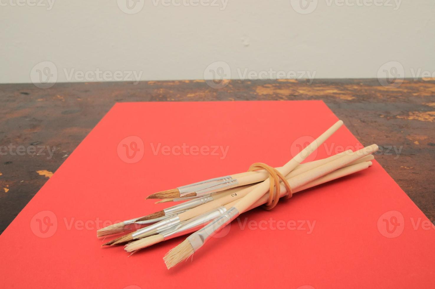 Painting brushes on a red paper photo