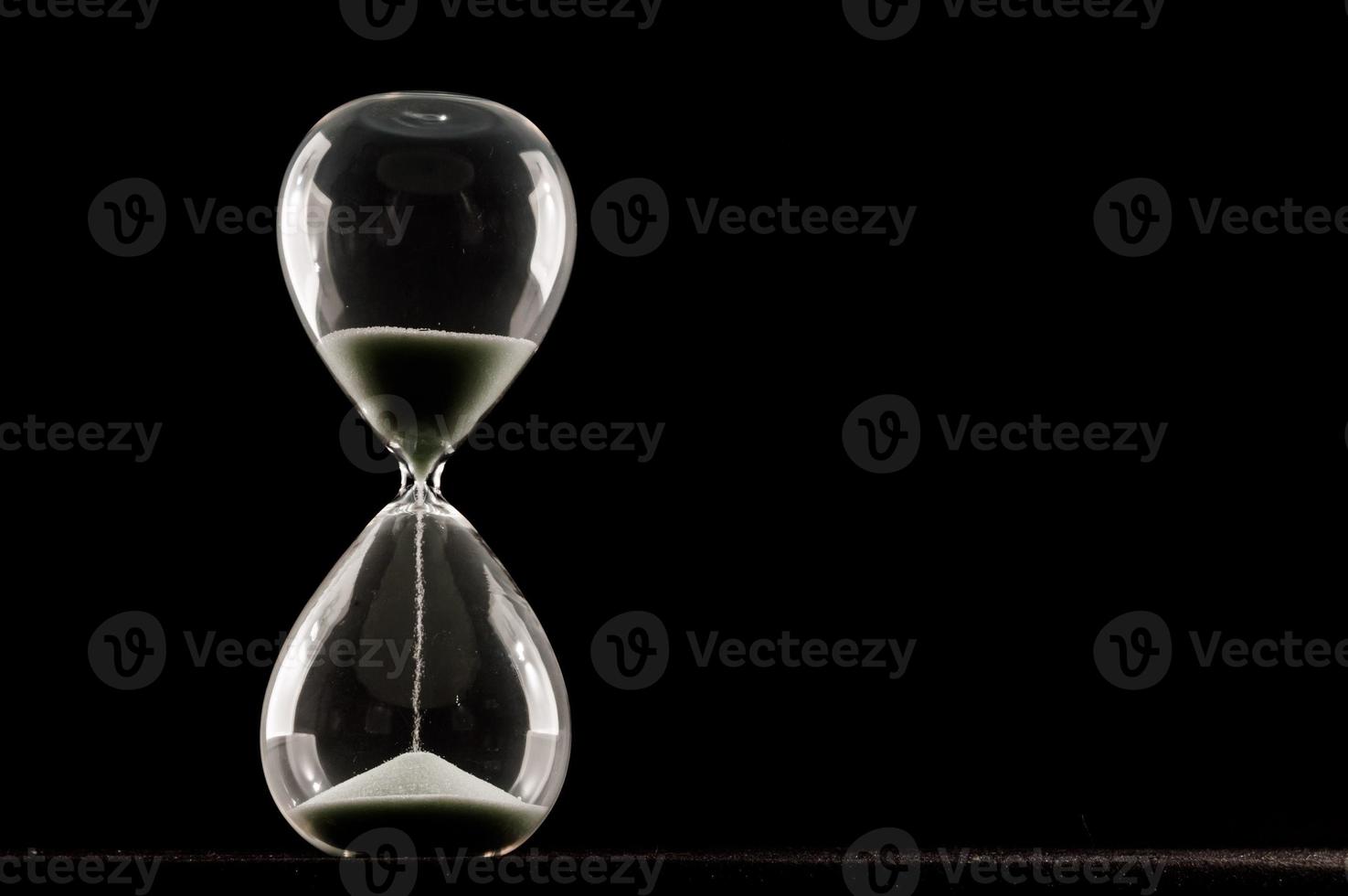 Hourglass on black background photo