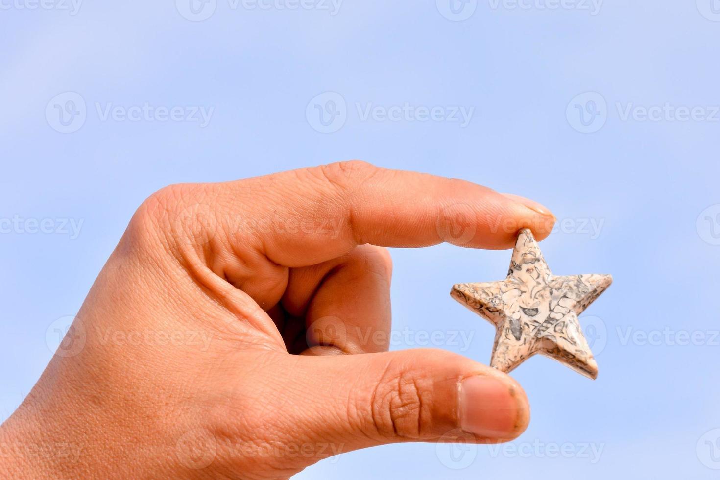 Hand holding a small star photo